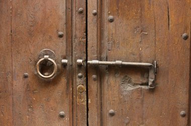 Ortaçağ kahverengi kapısında asılı duran, zamanın ve havanın dokunduğu bir orta çağ sapı. 