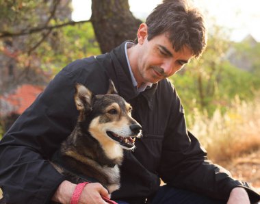 Güneşli bir günbatımının bulanık ışınlarıyla çevrili, sahibinin yanında oturan köpeğin mutlu ağızlık sesi. 