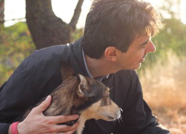 Güneşli bir günbatımının bulanık ışınlarıyla çevrili, sahibinin yanında oturan köpeğin mutlu ağızlık sesi. 