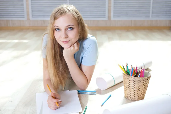 Junges Teenager-Mädchen auf dem Boden denkt und zeichnet — Stockfoto