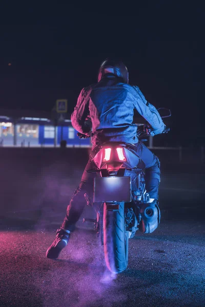 Motorcyklist Sitter Motorcykel Neonljus Tom Parkeringsplats Natten — Stockfoto