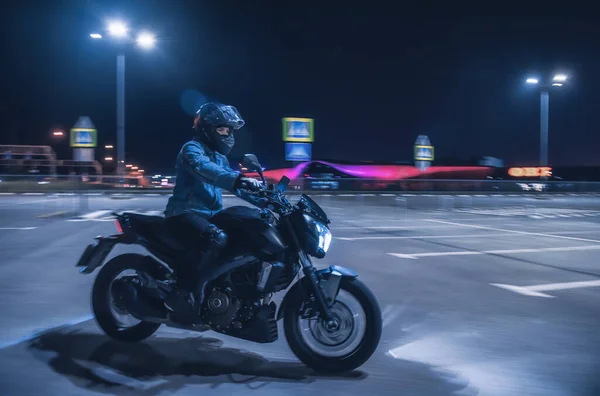 Motorcyclist Sits Motorbike Neon Light Empty Parking Lot Night — Stock Photo, Image