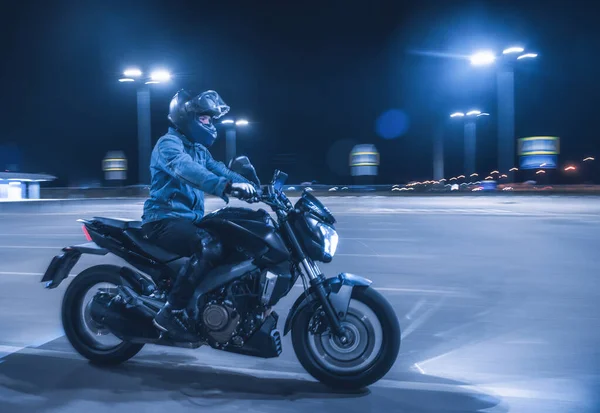 Motorcyklist Sitter Motorcykel Neonljus Tom Parkeringsplats Natten — Stockfoto