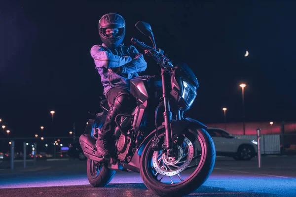 Motorcyclist Sits Motorbike Neon Light Empty Parking Lot Night — Stock Photo, Image