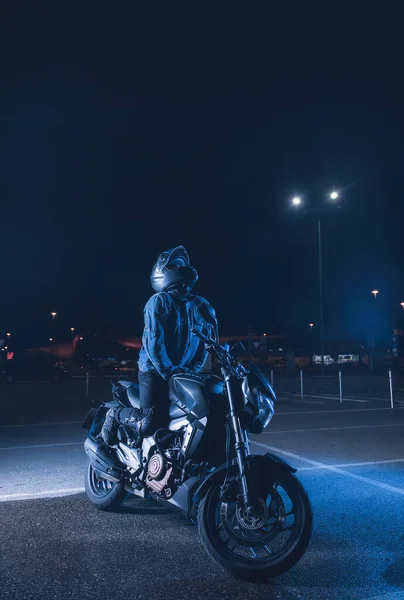 Motorcyclist Sits Motorbike Neon Light Empty Parking Lot Night — Stock Photo, Image