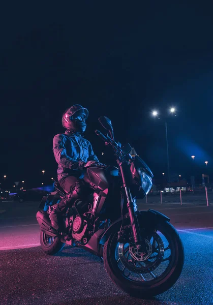 Motociclista Senta Uma Moto Luz Néon Estacionamento Vazio Noite — Fotografia de Stock