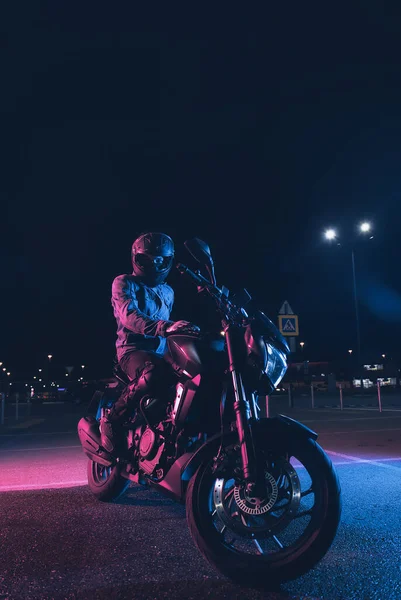 Motorcyclist Sits Motorbike Neon Light Empty Parking Lot Night — Stock Photo, Image