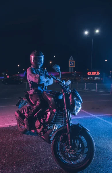 Motorcyclist Sits Motorbike Neon Light Empty Parking Lot Night — Stock Photo, Image