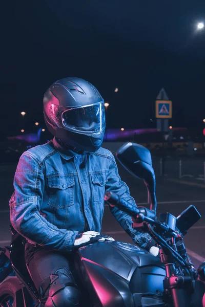 Motorcyklist Sitter Motorcykel Neonljus Tom Parkeringsplats Natten — Stockfoto