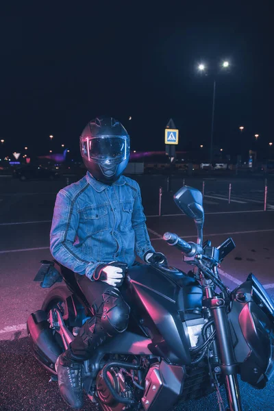 Мотоциклист Сидит Мотоцикле Неоновом Свете Пустой Парковке Ночью — стоковое фото