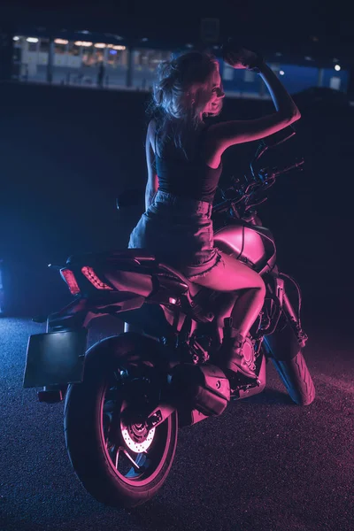 空の駐車場の夜のバイクのネオンライトの少女の肖像画 — ストック写真