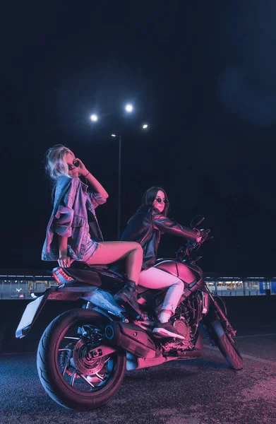 Par Meninas Apaixonadas Uma Moto Nos Raios Luz Néon Estacionamento — Fotografia de Stock