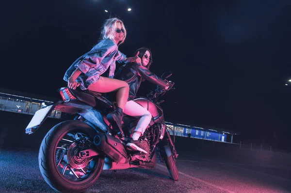 Пара Закоханих Дівчат Мотоциклі Променях Неонового Світла Порожній Парковці Вночі — стокове фото