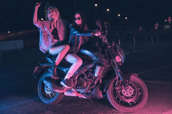 Пара Закоханих Дівчат Мотоциклі Променях Неонового Світла Порожній Парковці Вночі — стокове фото