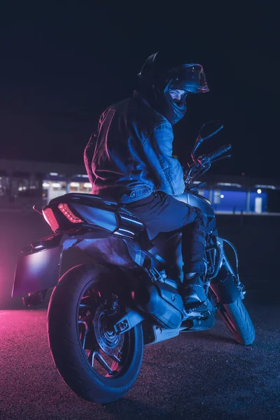 Motociclista Senta Uma Moto Luz Néon Estacionamento Vazio Noite — Fotografia de Stock