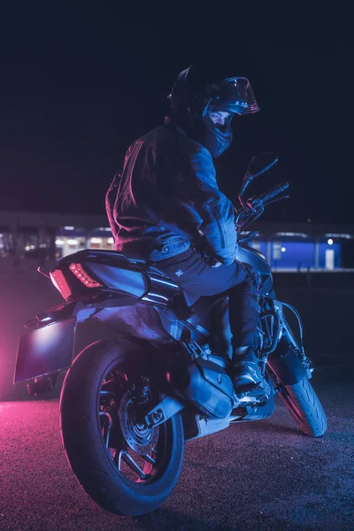 Motociclista Senta Uma Moto Luz Néon Estacionamento Vazio Noite — Fotografia de Stock
