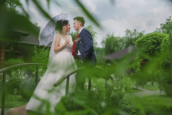 Portrait of an international loving couple of newlyweds against the backdrop of nature and flowers