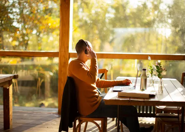 Zakenman Met Koptelefoon Aan Het Werk Laptop Zonnig Herfstcafé — Stockfoto