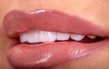 Seksi, baştan çıkarıcı, dolgun dudaklı kadın gülüşü. Beyaz güzel dişleri beyazlatan seramik taç takan genç bayan gülümsüyor. Diş zirkon implantları restorasyon cerrahisi moda konsepti