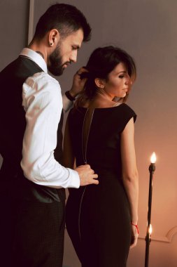 Seksi, zarif takım elbiseli, vahşi sakallı bir adamın portresi çatı katında seksi iç çamaşırlı, seksi bir kıza dokunuyor. Çift aşk hikayesi kavramı