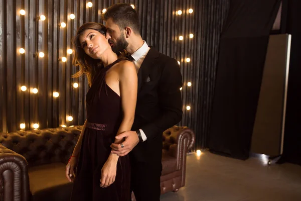 Seksi, zarif takım elbiseli, vahşi sakallı bir adamın portresi çatı katında seksi iç çamaşırlı, seksi bir kıza dokunuyor. Çift aşk hikayesi kavramı