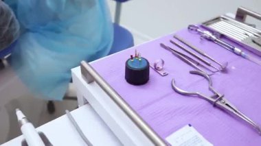 Klinikteki kadın hastalara diş tedavisi yapan bir diş hekimi. Enstrümanı kadın profesyonel doktor stomatolog diş hekimi alıyor. Arkaplanda diş ekipmanı. 