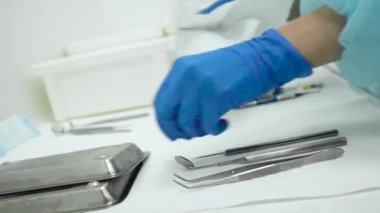 Sağlık çalışanı diş hekimliğinde temizlik temizleme aletleri hazırlıyor. Diş kliniği asistanı stomatolojik aletleri fırça ve sterilizasyon ile yıkıyor. Salgın sırasında yakın çekim koruma