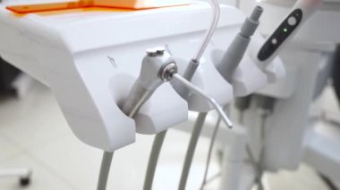 Yakın çekim dişçi aletleri. Macro klinikteki hastaya diş tedavisi uyguluyor. Profesyonel doktor stomatolog. Arkasında dişçi var..