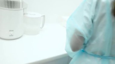 Sağlık çalışanı diş hekimliğinde temizlik temizleme aletleri hazırlıyor. Diş kliniği asistanı stomatolojik aletleri fırça ve sterilizasyon ile yıkıyor. Salgın sırasında yakın çekim koruma