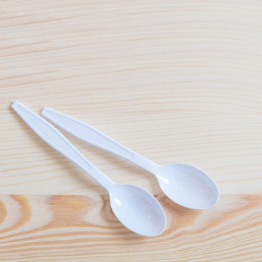 Doğal ahşap zemin üzerine plastik kaşık.