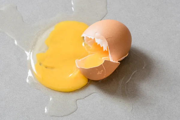 Egg drop crack splattered down on ceramic tile. — Stock Photo, Image