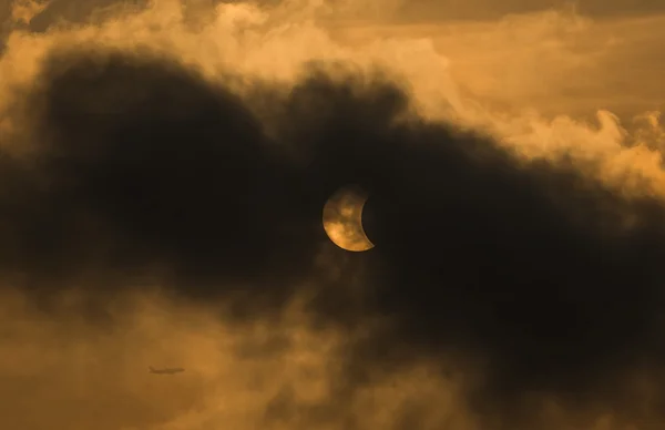 Měsíc, zahrnující slunce v částečné zatmění s dramatickým cloud. — Stock fotografie