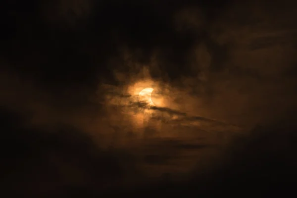 La Luna cubriendo el Sol en un eclipse parcial con una nube dramática . — Foto de Stock