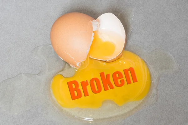 Bad wording on Egg drop crack splattered down on ceramic tile. — Stock Photo, Image