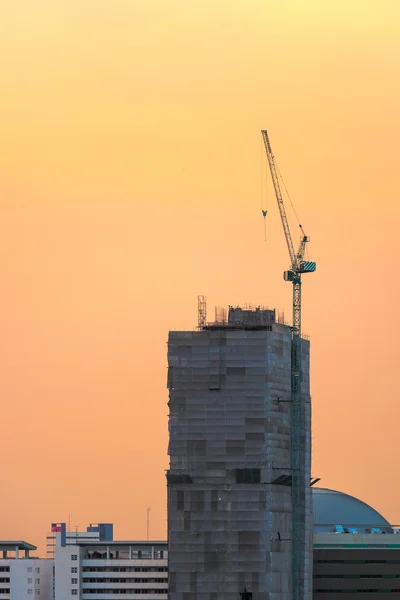 工业建筑起重机在落日的天空背景的地盘 — 图库照片