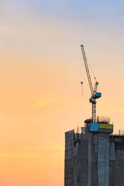 Industriellt byggande kranar på byggarbetsplatsen med solnedgång himmel bakgrund — Stockfoto