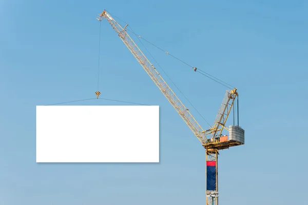 Construction Crane håller en tom skylt med blå himmel bakgrund. — Stockfoto