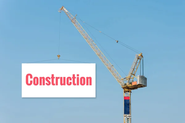 Industriële bouw kraan Holding een Billboard met bouw tekst op blauwe hemel achtergrond. — Stockfoto