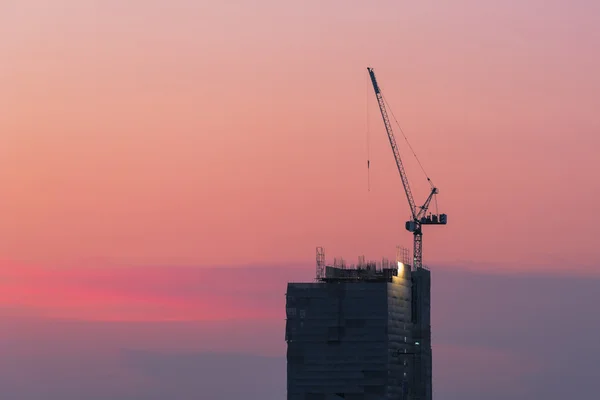 建筑工地的工业起重机，具有日落天空背景 — 图库照片