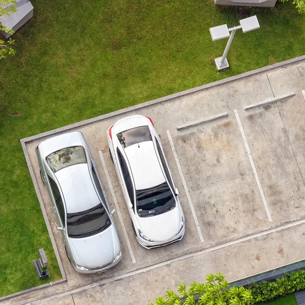 Top view of parking area with small garden in modern building