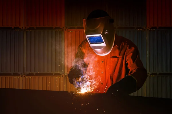 Industriële lasser met veiligheidsuitrusting en beschermend masker lassen staalstructuur in de bouw fabriek — Stockfoto