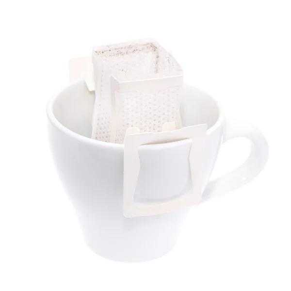 Sac goutte à goutte café suspendu sur une tasse de café isolé sur fond blanc . — Photo