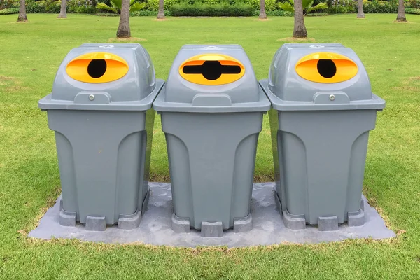 Drie plastic recyclebakken om verschillende afvalproducten in Park te scheiden — Stockfoto