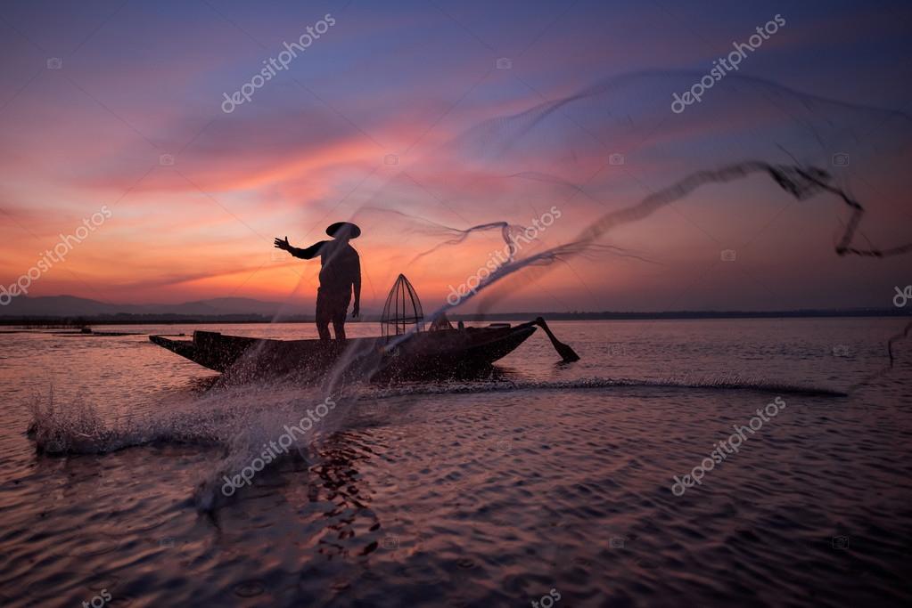 Silhouette of Asian fisherman on wooden boat throwing a net for catching freshwater  fish in nature river in the early during sunrise time Stock Photo by  ©teddybearpicnic 123311904