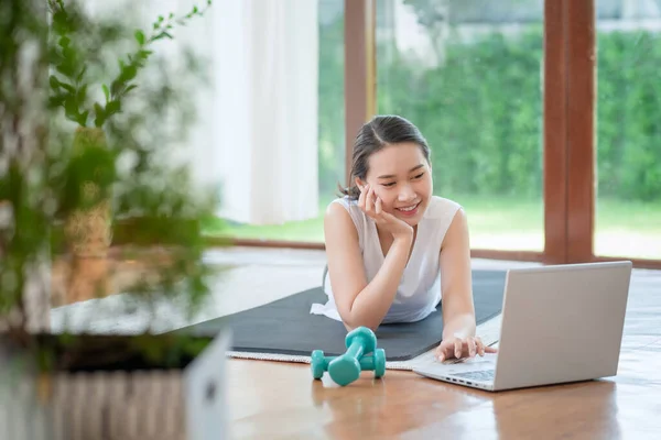 Beautiful asian woman staying fit by exercising at home for healthy trend lifestyle