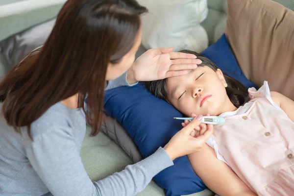 亚洲母亲用温度计检查孩子的体温 结果孩子在家里发烧生病了 — 图库照片#