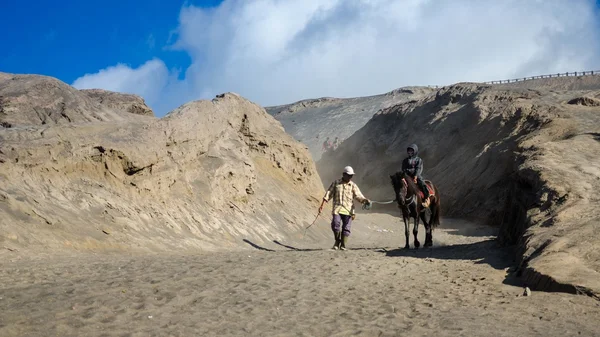東ジャワ, インドネシア-5 05： ブロモ山で馬に乗る観光客、活発な火山は 5 月 05,2013 東ジャワ、インドネシアの最も訪問された観光の名所の 1 つ. — ストック写真