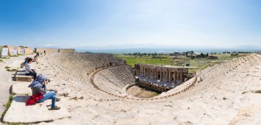 PAMUKKALE, TURKEY - April 16: Tourists watching the ancient theater of the Roman city of Hierapolis on April 16, 2014 in Pamukkale, Turkey. The site is a UNESCO World Heritage site