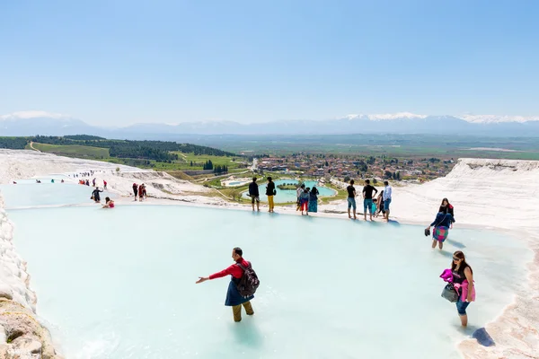 PAMUKKALE, TURKEY- APRIL,12: Tourists on Pamukkale travertines on April 12, 2015 in Pamukkale, Turkey. Pamukkale, UNESCO world heritage site, nowadays become one of the most visited sights in Turkey. — Stock Photo, Image