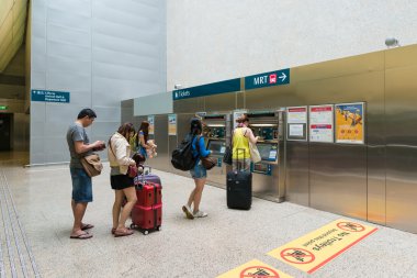 Unidentified people buy tickets at The Mass Rapid Transit (MRT) on July 10, 2015 in Singapore.